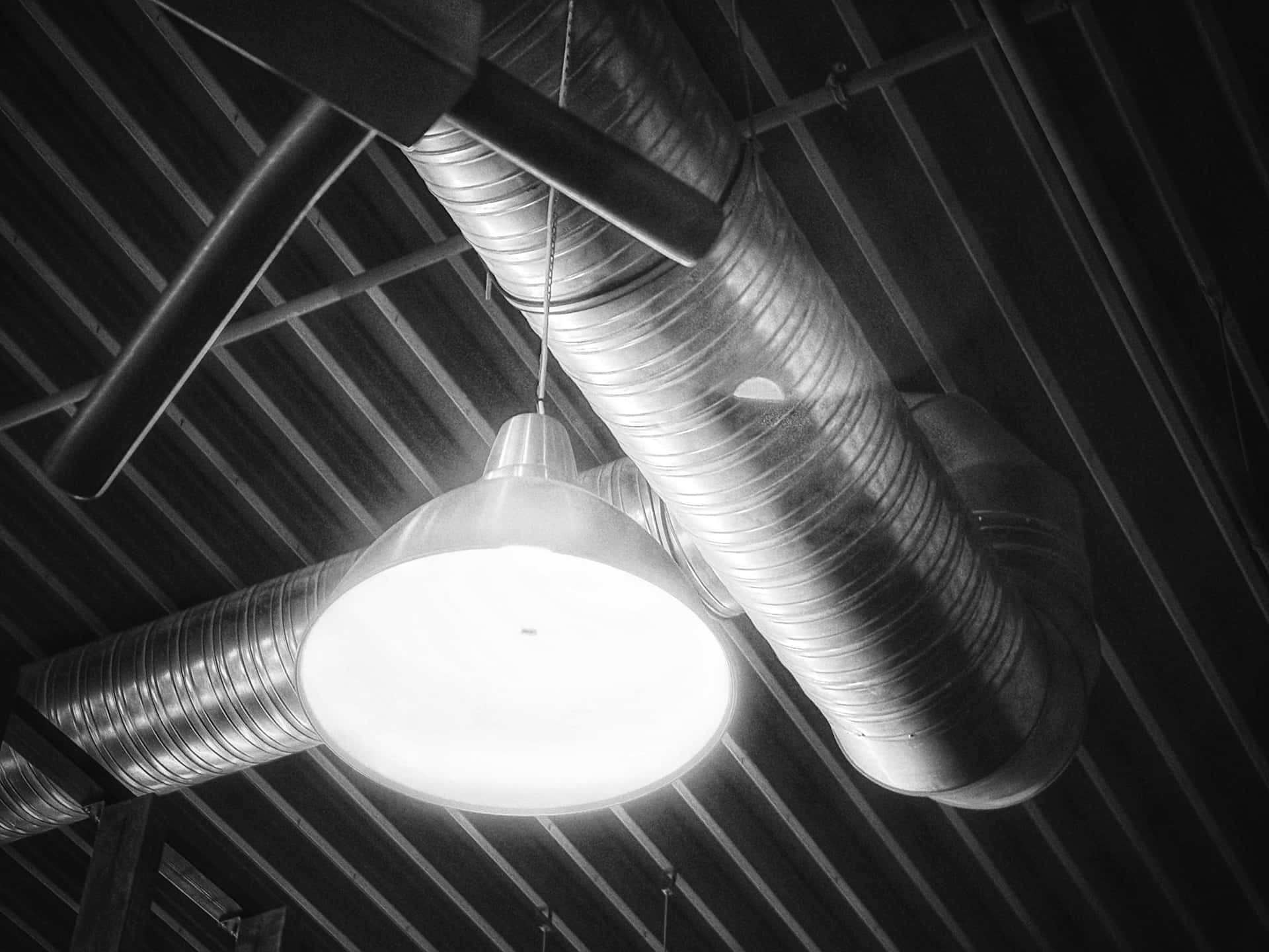 Plafond industriel avec gaines de ventilation et éclairage suspendu