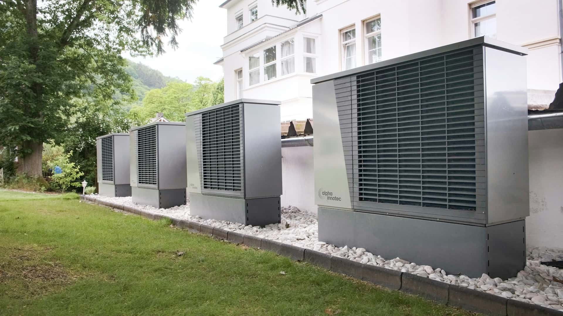 Rangée de pompes à chaleur collectives air/eau installées au pied d'un immeuble